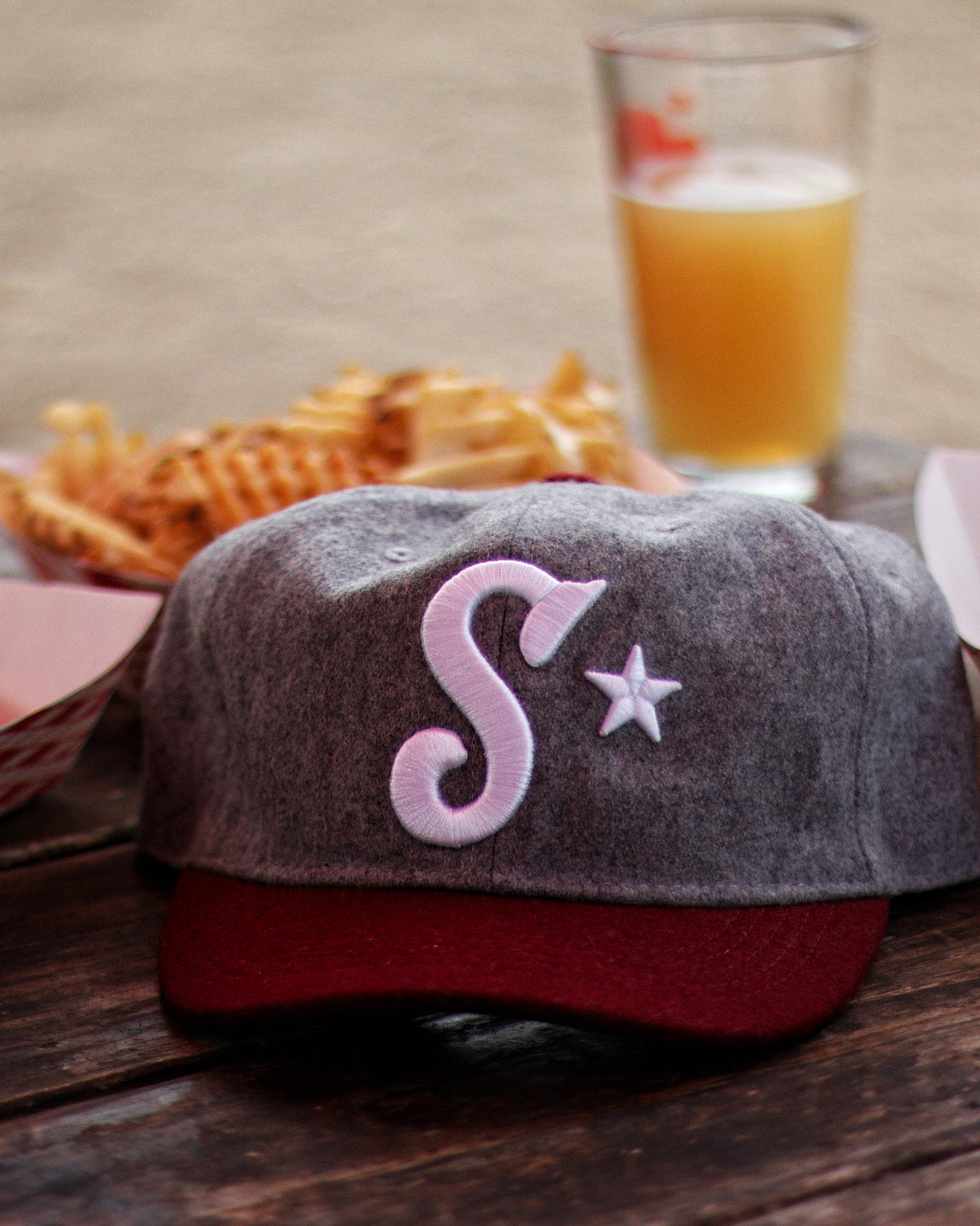Southside Golf Co wool golf hat close up with embroidered S logo on table with beer and fries