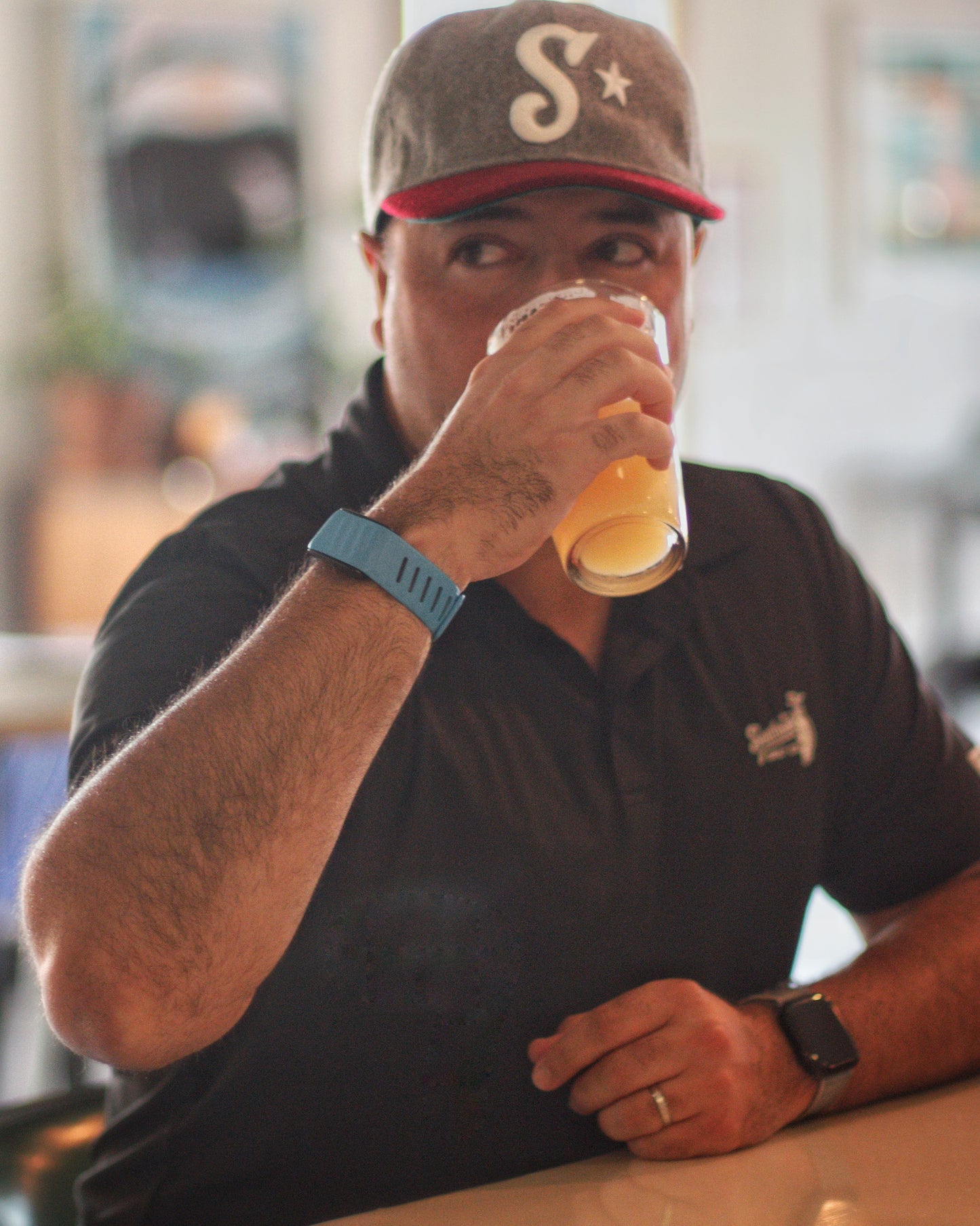 Man wearing Southside Golf Co heritage golf hat drinking beer in casual bar setting in Austin Texas