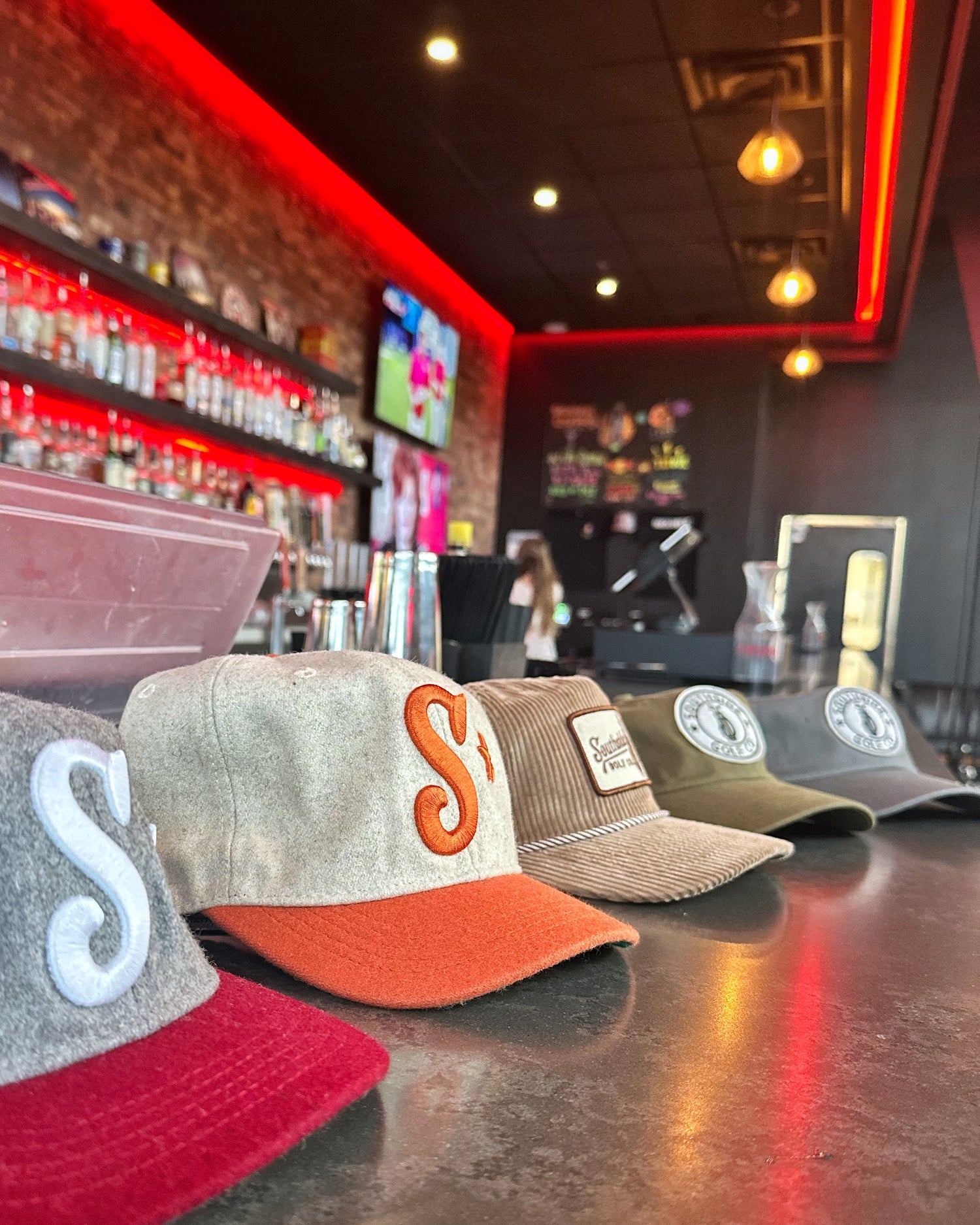 Southside Golf Co golf hats on display at bar, corduroy and cotton unstructured caps in limited colors.