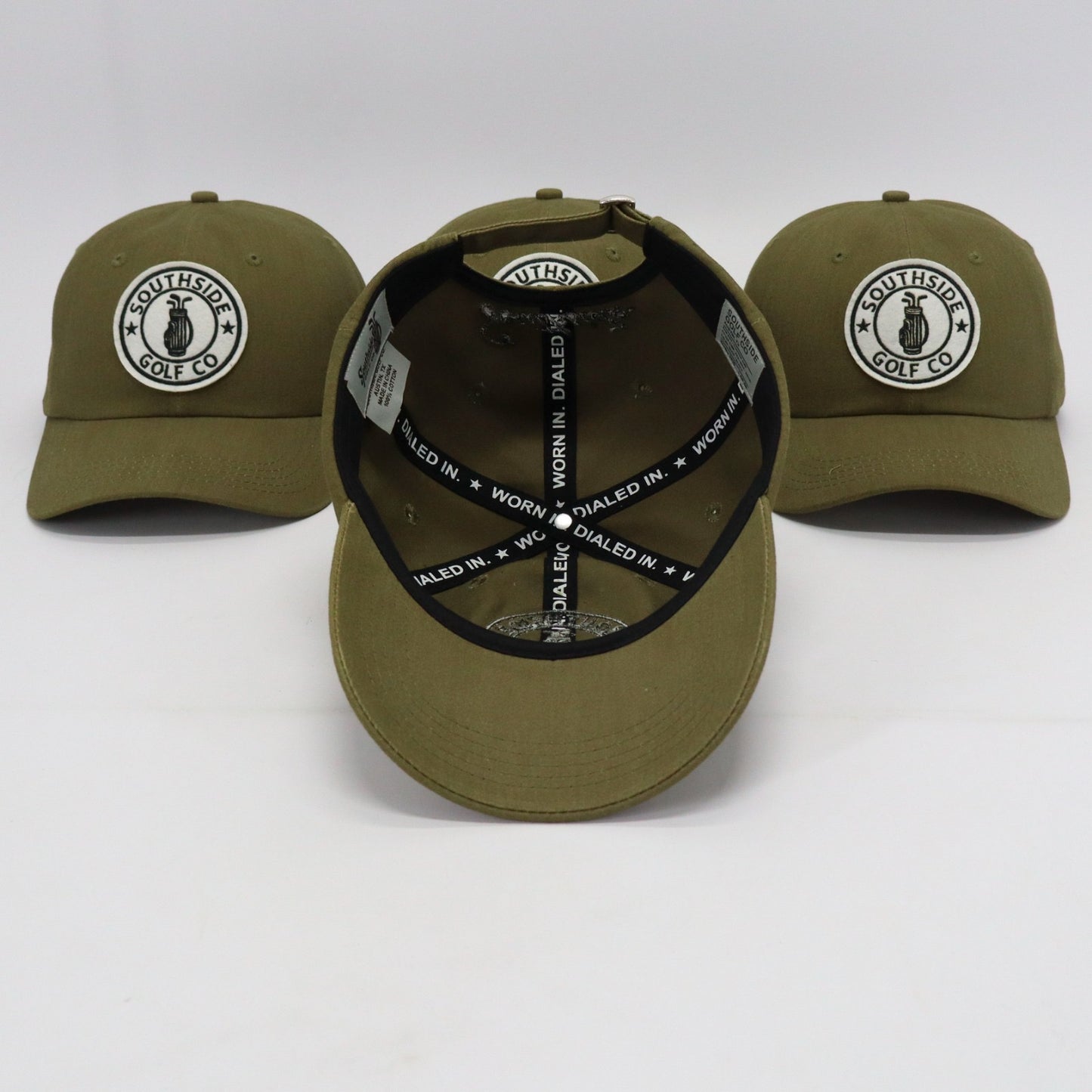 Multiple Southside Golf Co olive unstructured dad hats showing embroidered logo patch and ‘Worn In. Dialed In.’ interior taping on white background.