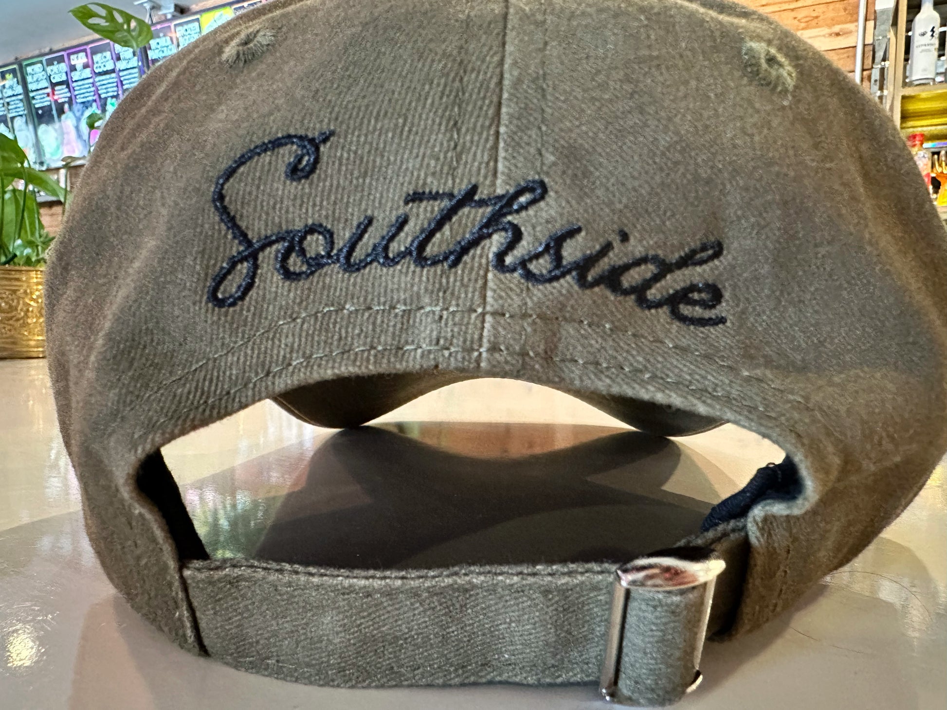Back view of Southside Golf Co olive unstructured dad hat with adjustable strap and embroidered script logo.