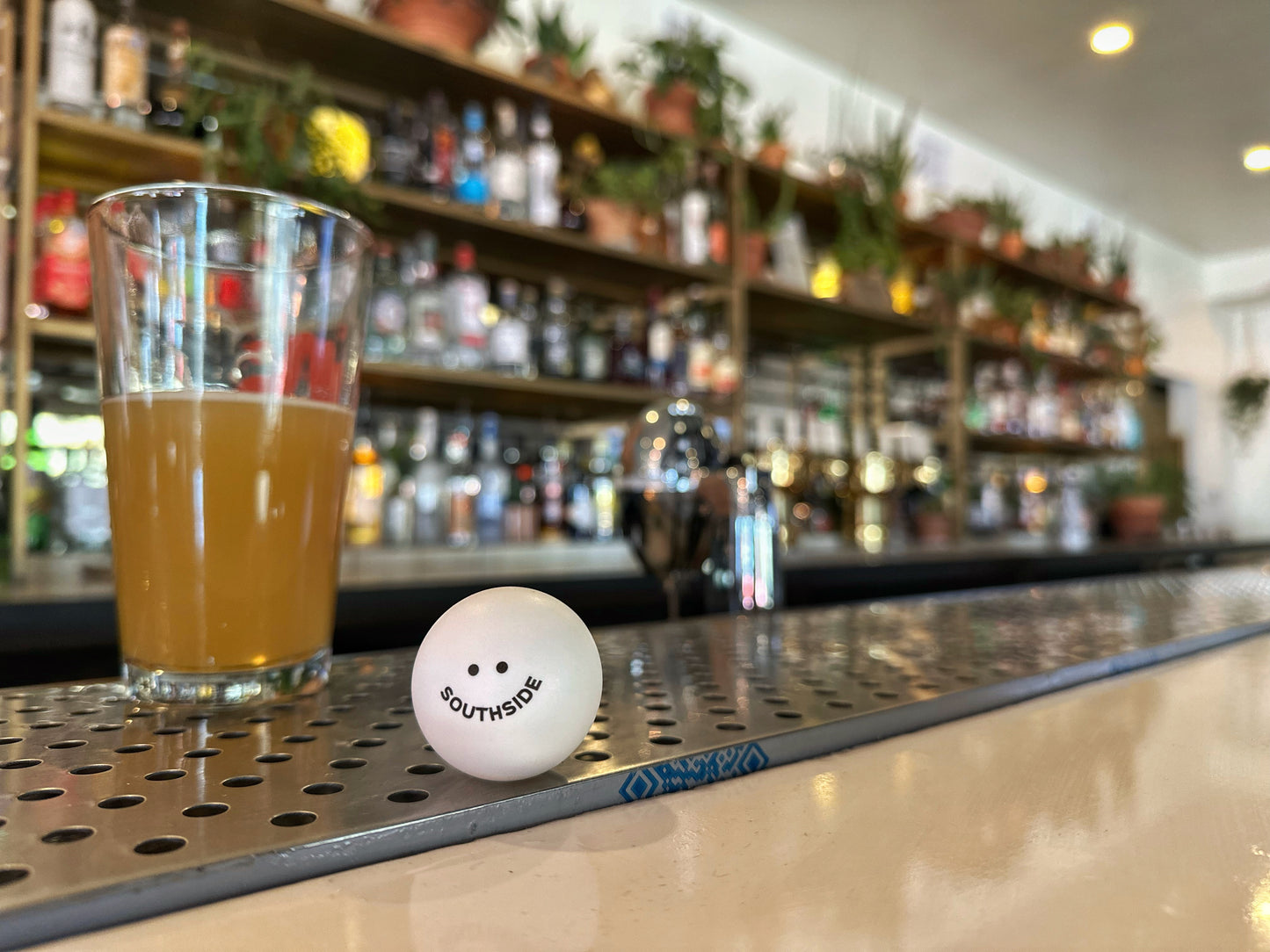 Southside Golf Co ping pong ball on bar counter next to glass of beer