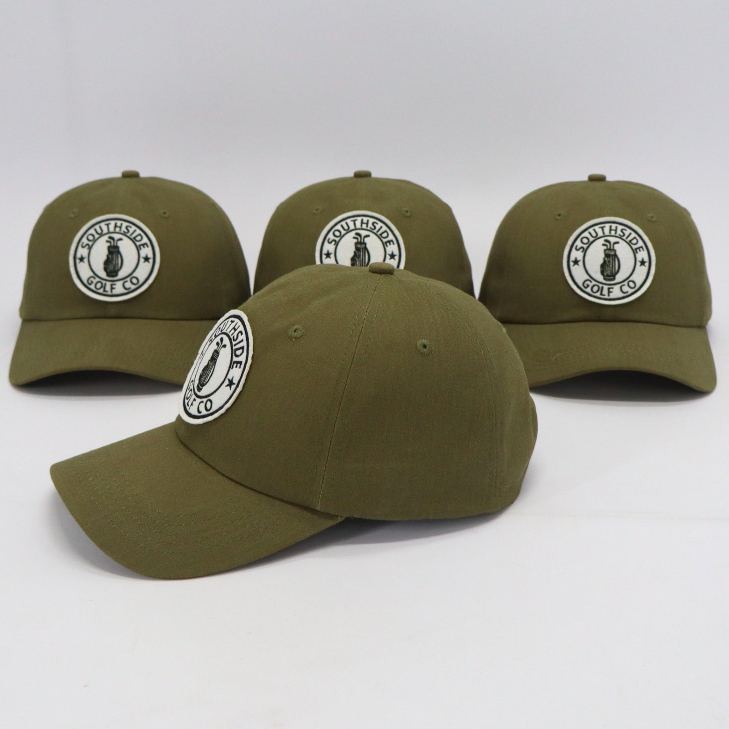 Multiple Southside Golf Co olive unstructured dad hats with embroidered logo patch on white background.