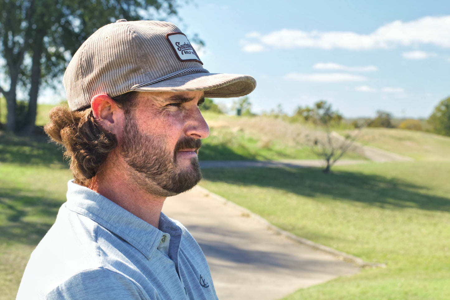 Man wearing a Southside Golf Co heritage corduroy 5-panel golf hat on an outdoor golf course in Austin, Texas