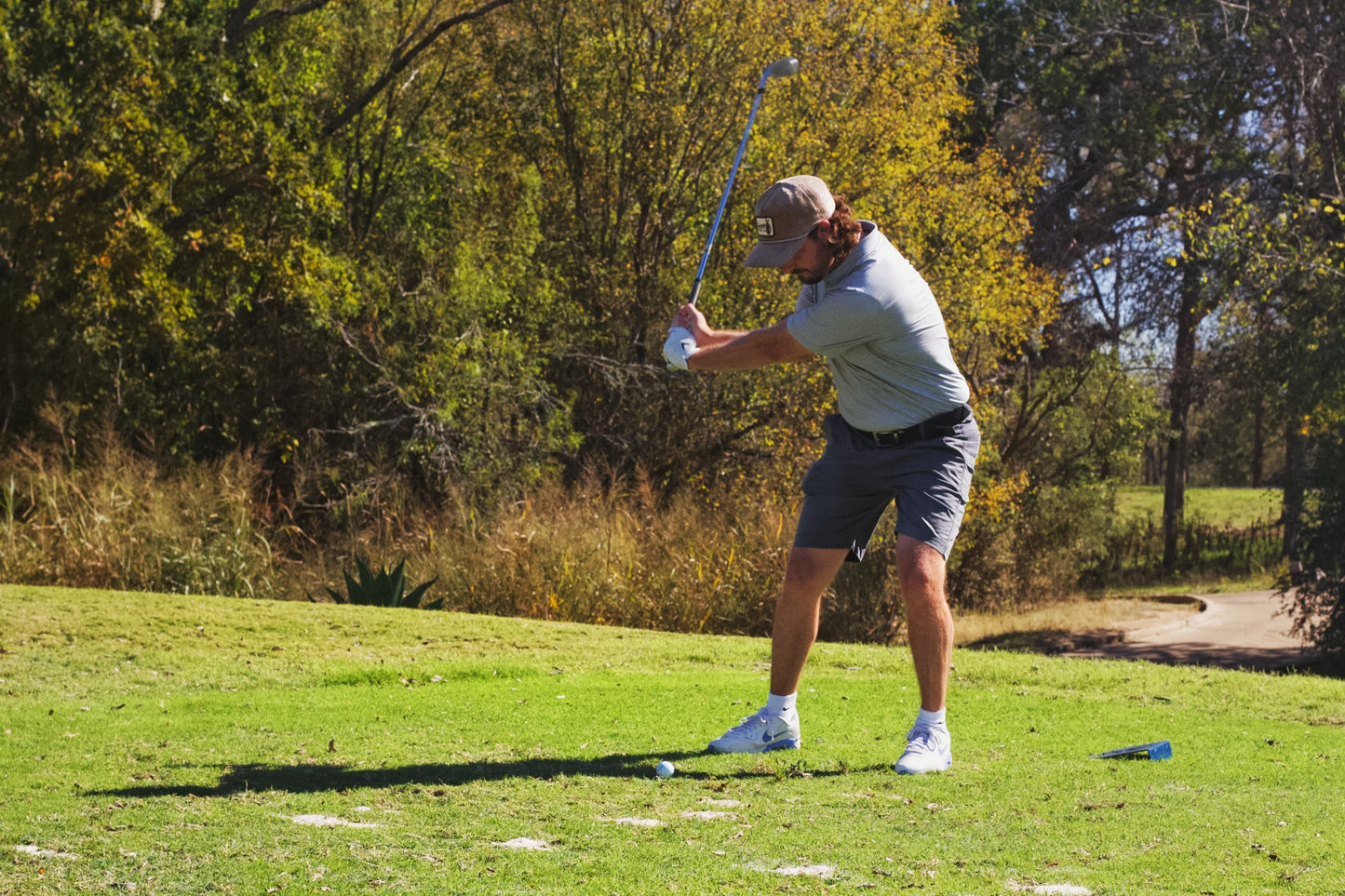 Golfer wearing Southside Golf Co Heritage corduroy 5-panel hat during a tee shot on a Texas golf course