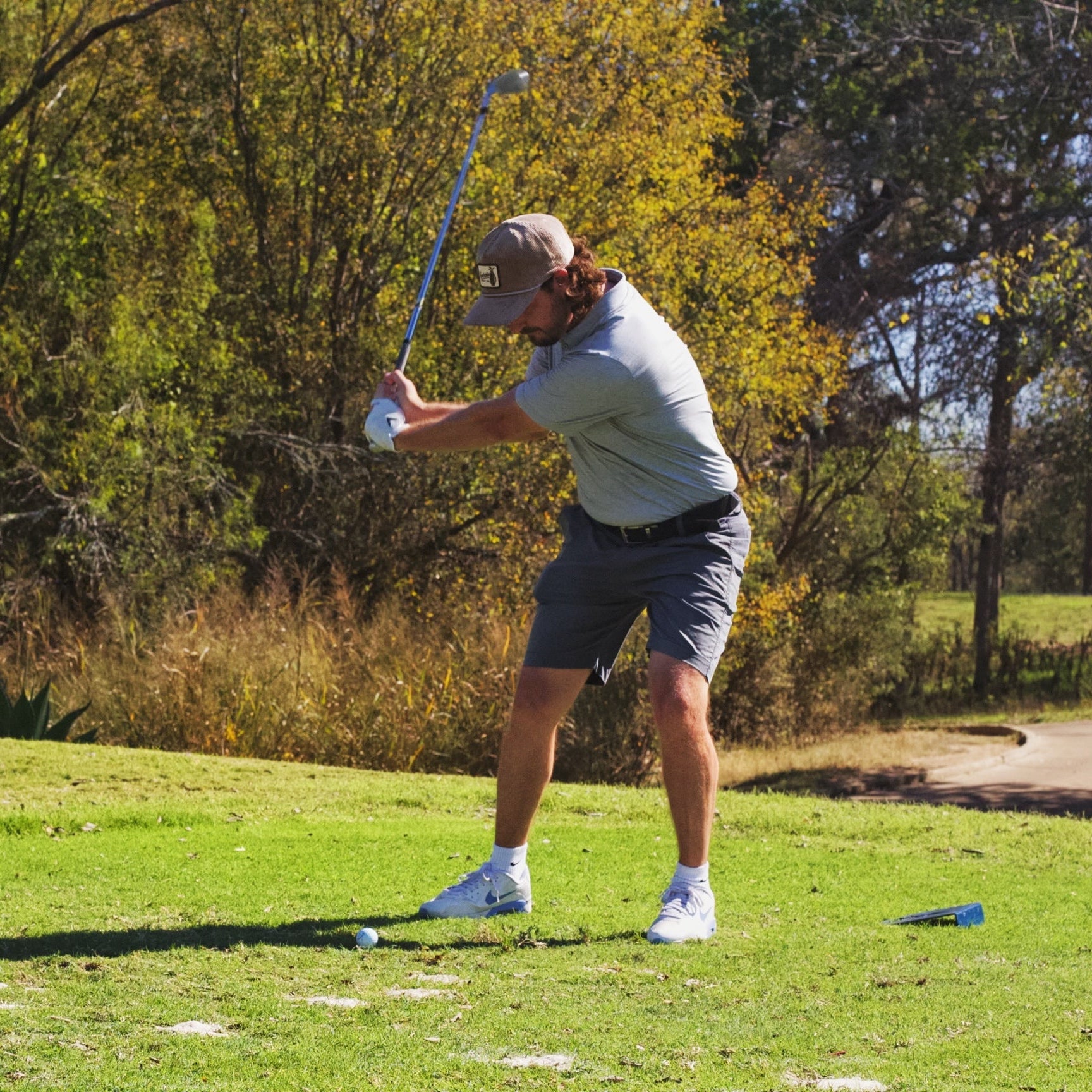 Golfer wearing Southside Golf Co Heritage corduroy 5-panel hat during a tee shot on a Texas golf course
