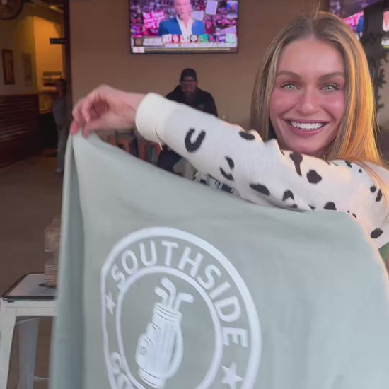 Southside Golf Co heavyweight hoodie First Edition golf apparel, model holding logo hoodie