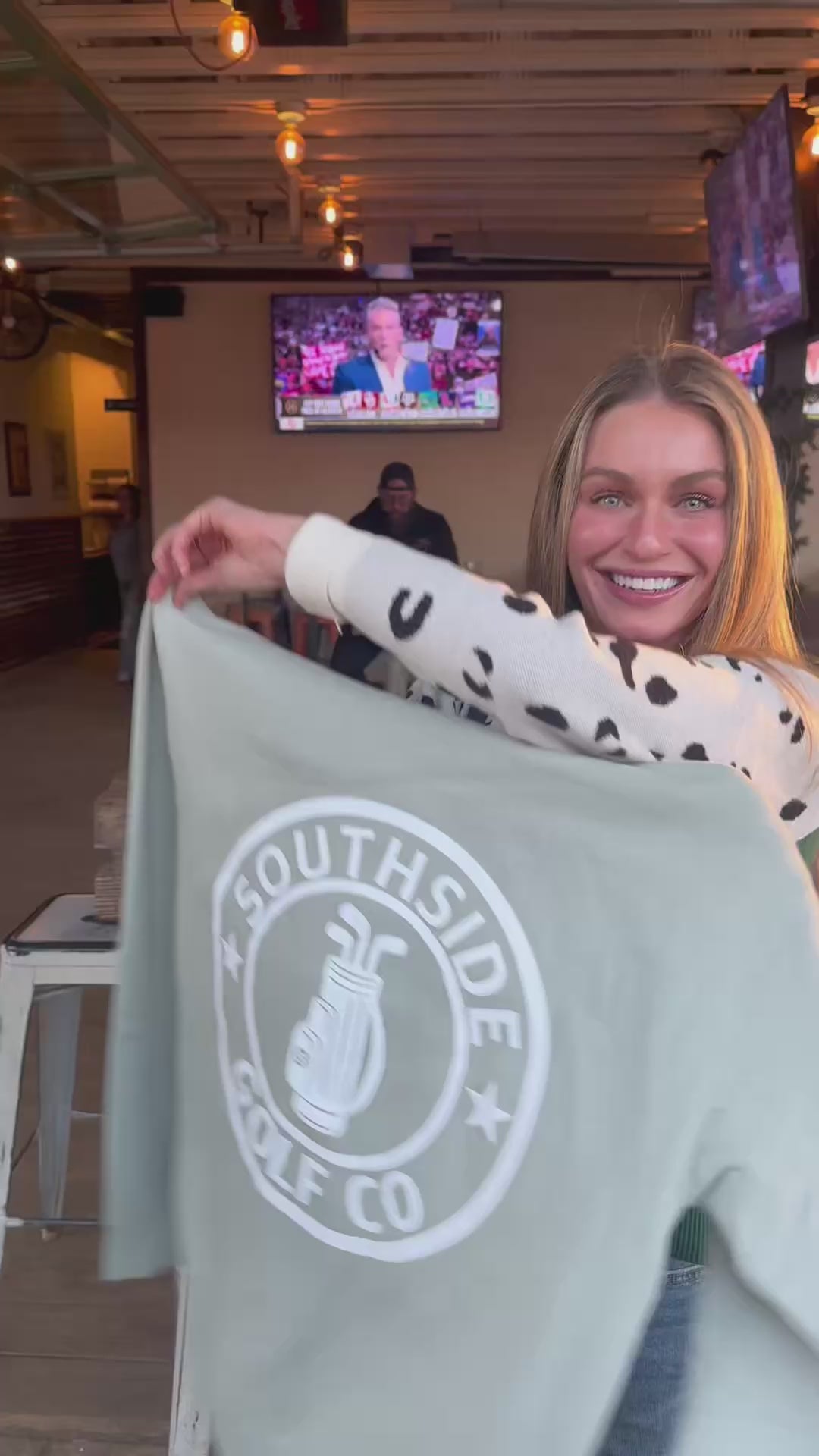 Southside Golf Co heavyweight hoodie First Edition golf apparel, model holding logo hoodie